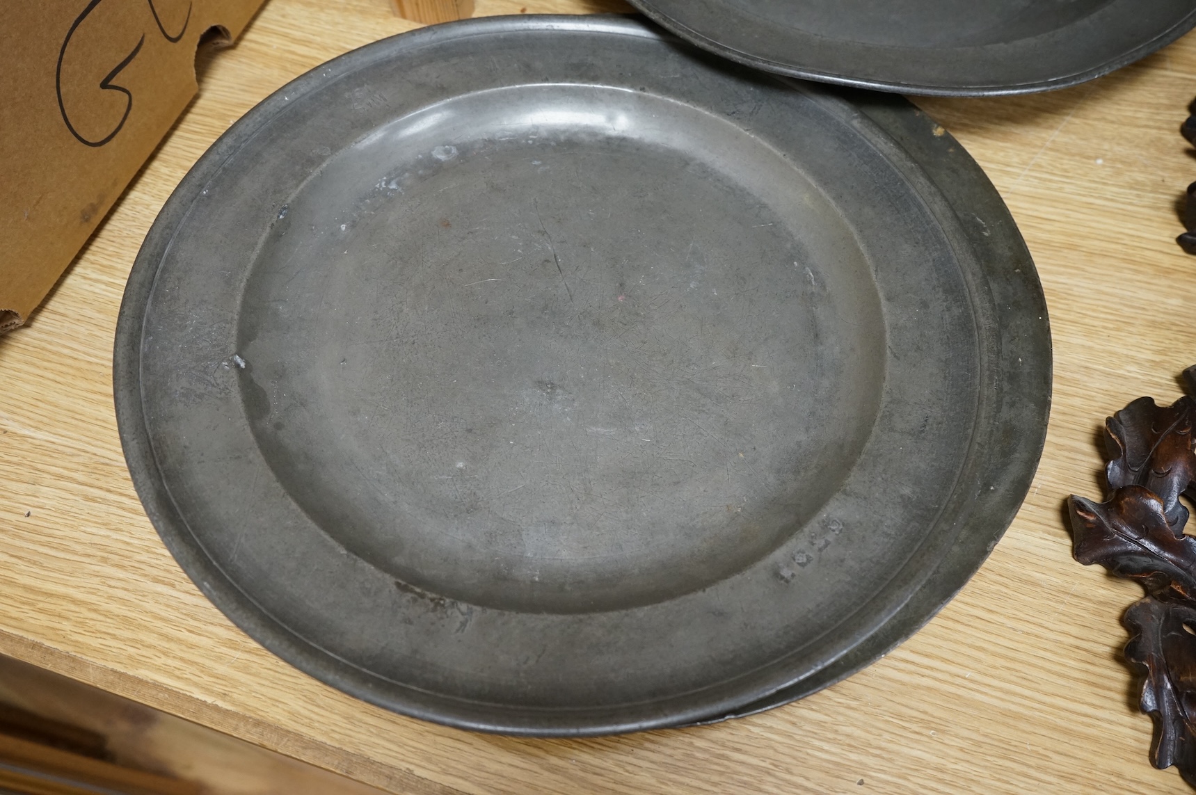 Three Pewter chargers, a large dish and a plate, c.1800, largest dish 42cm diameter (5)